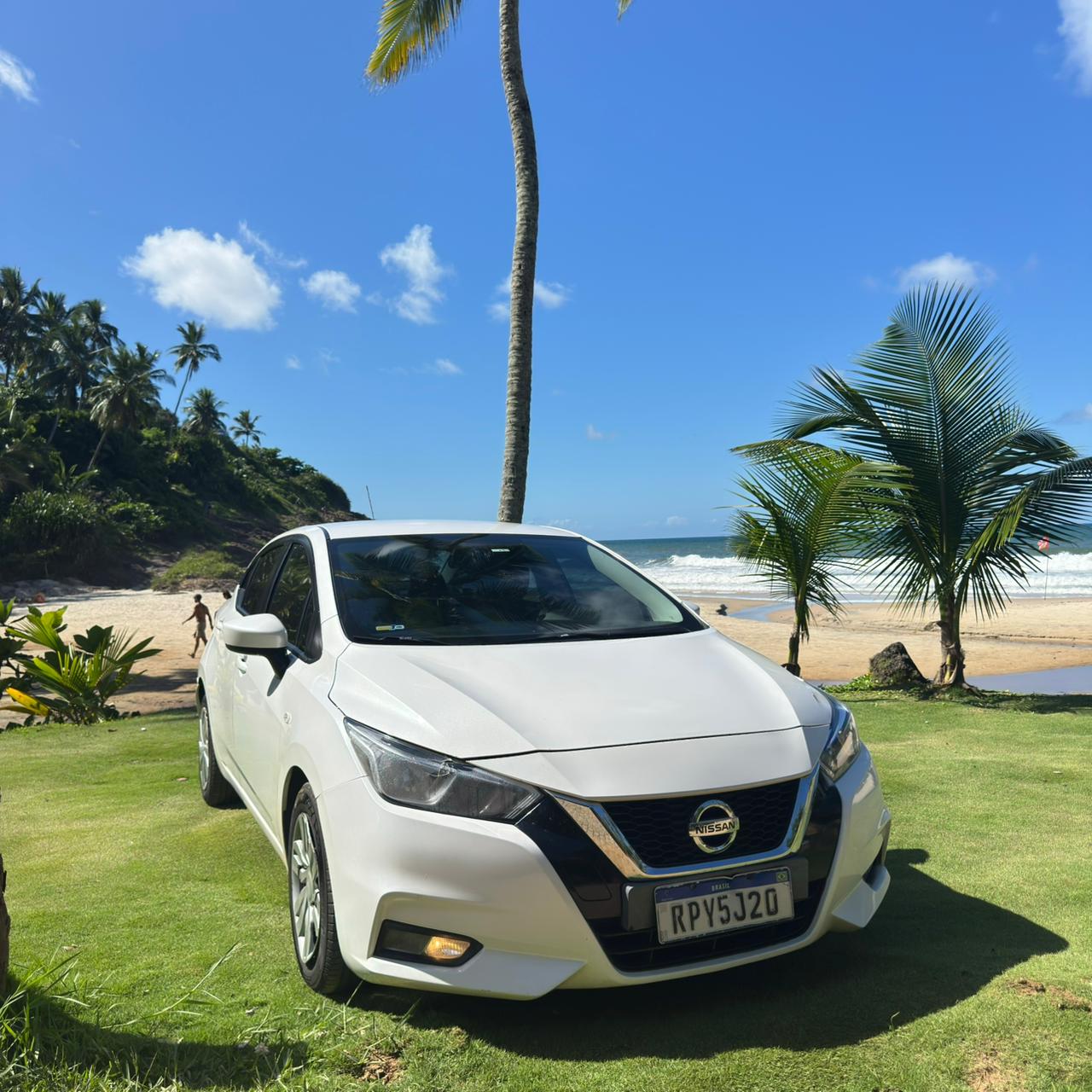 White transfer vehicle near a beach landscape in Itacare, Bahia